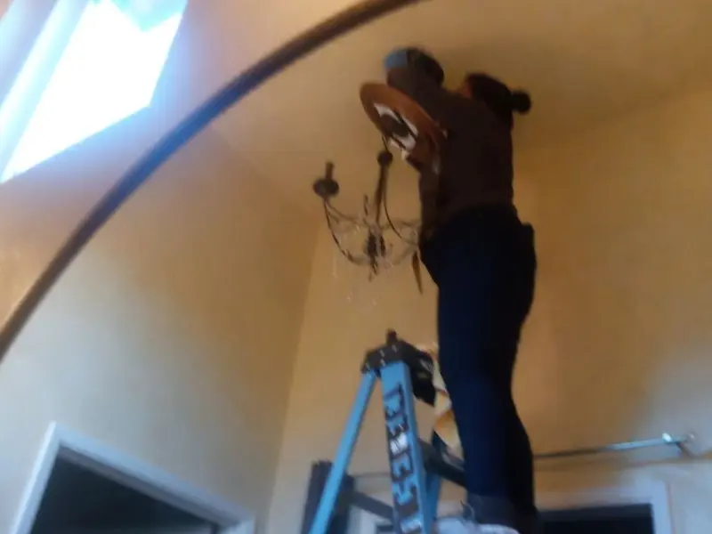 Electrician installing a chandelier in a Woodstock residence